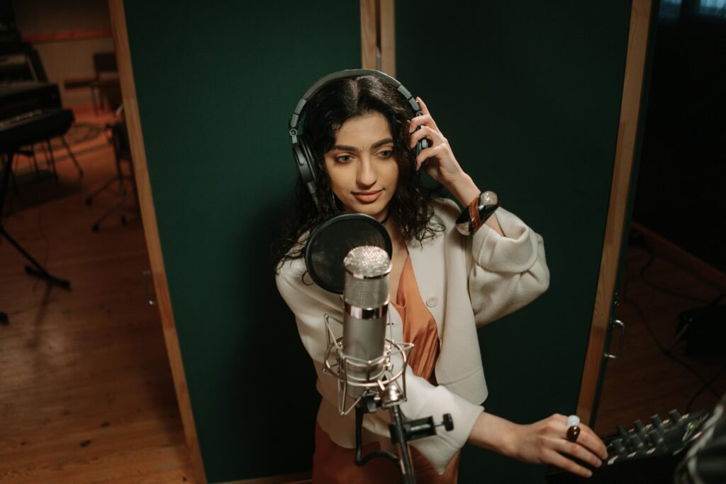 Professional female musician recording vocals in a music studio.